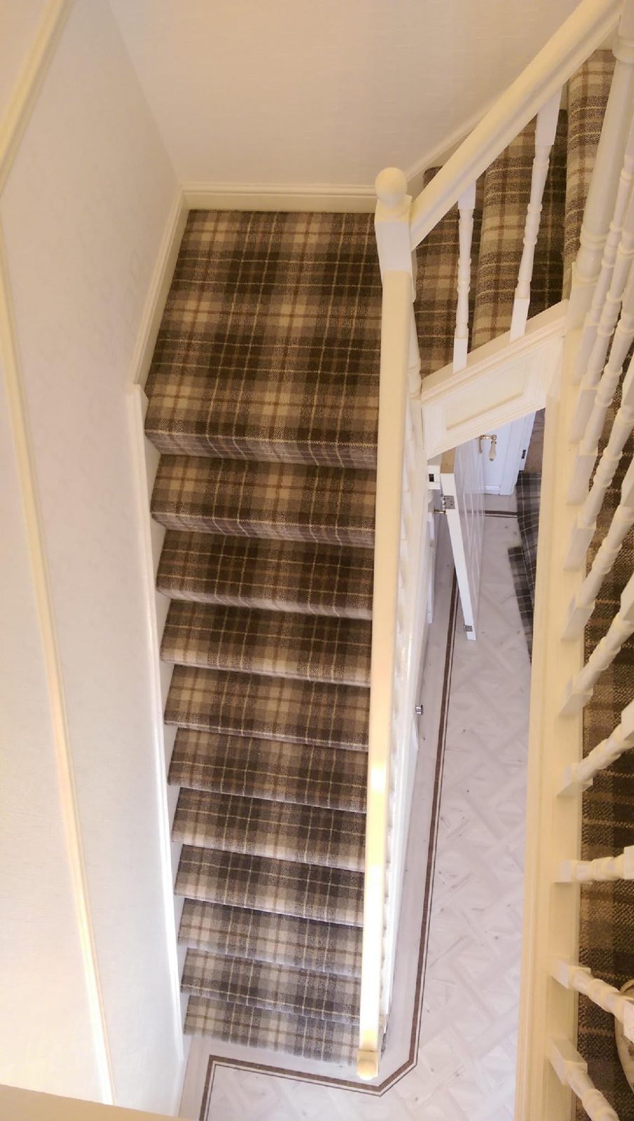 Tartan carpet fitted up a straight flight of stairs