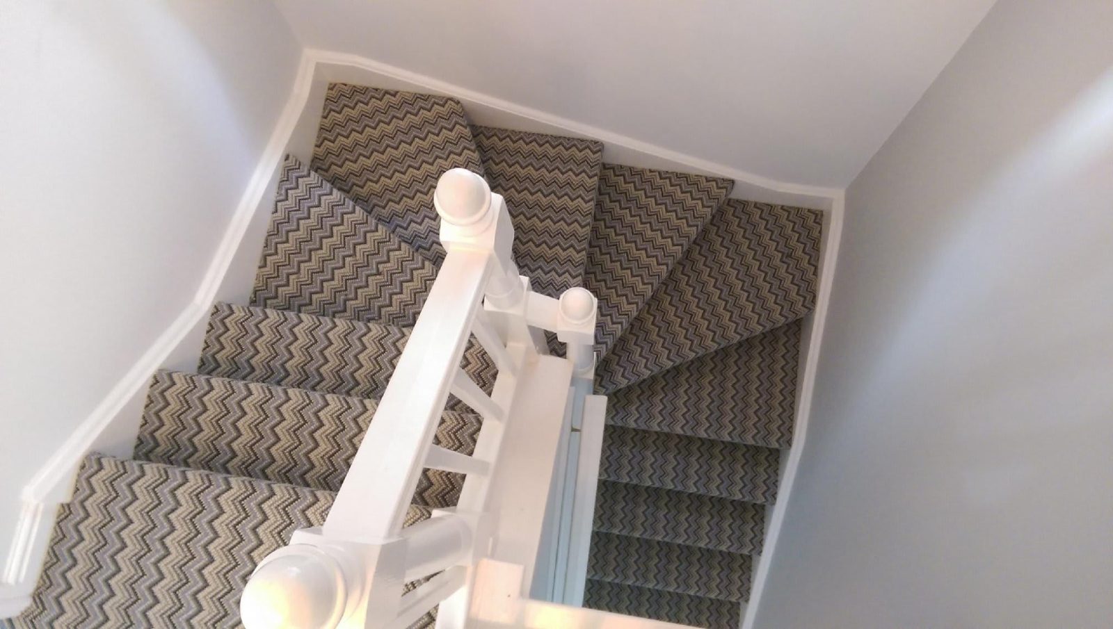 Zigzag patterned carpet fitted on a winding staircase