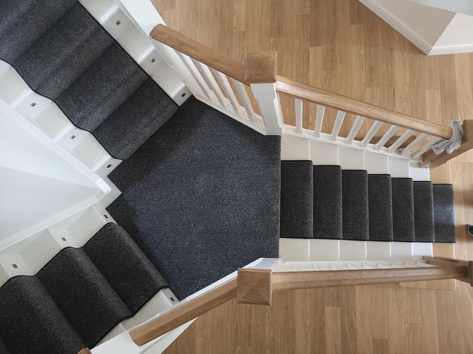 Charcoal carpet fitted across a landing and down the stairs